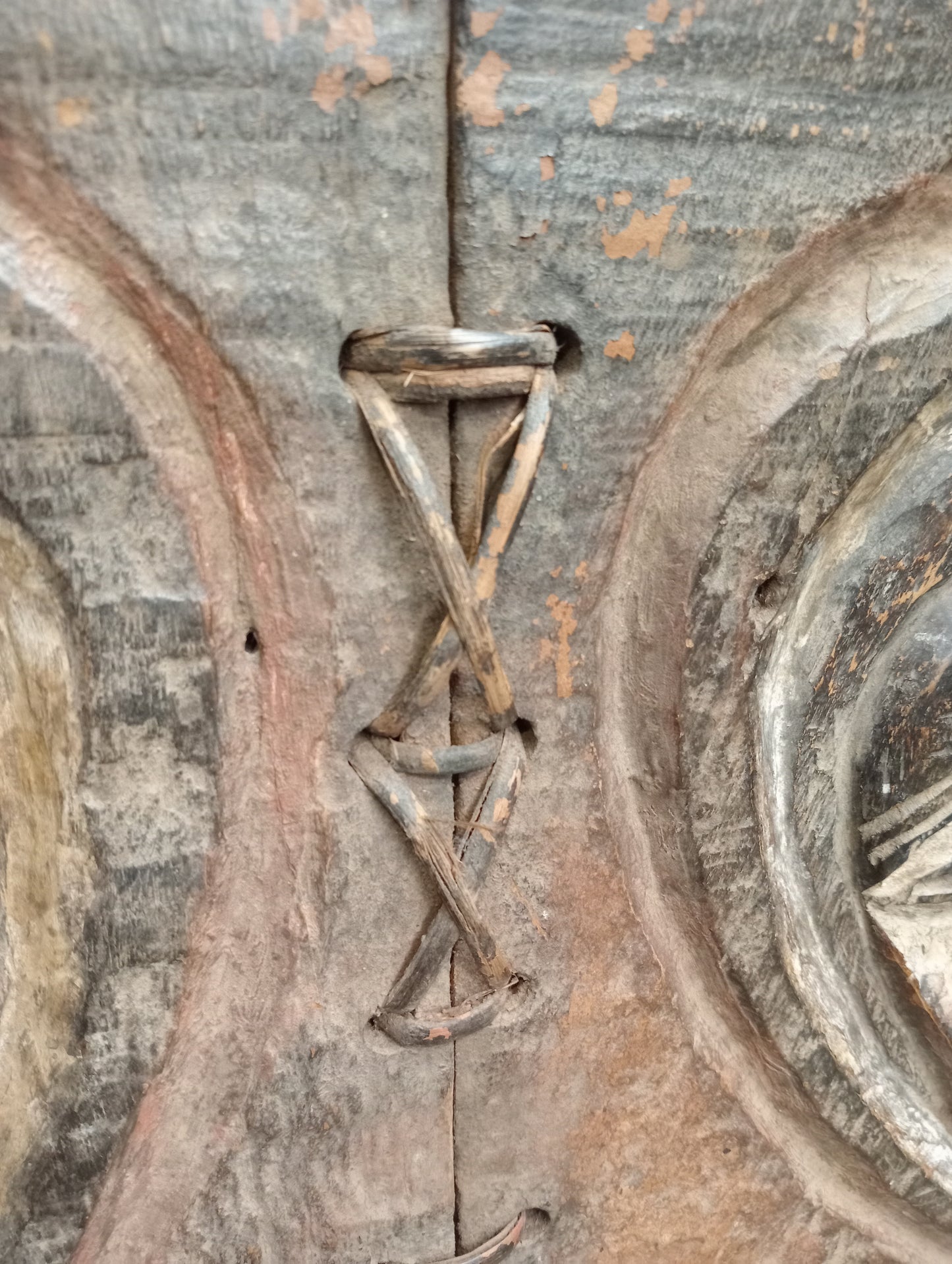African granary door with carved heart shape faces and the inner eye
