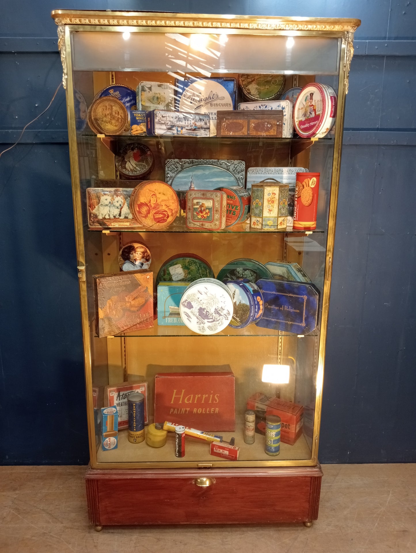 Brass glazed shop cabinet display with single drawer on brass feet with lights
