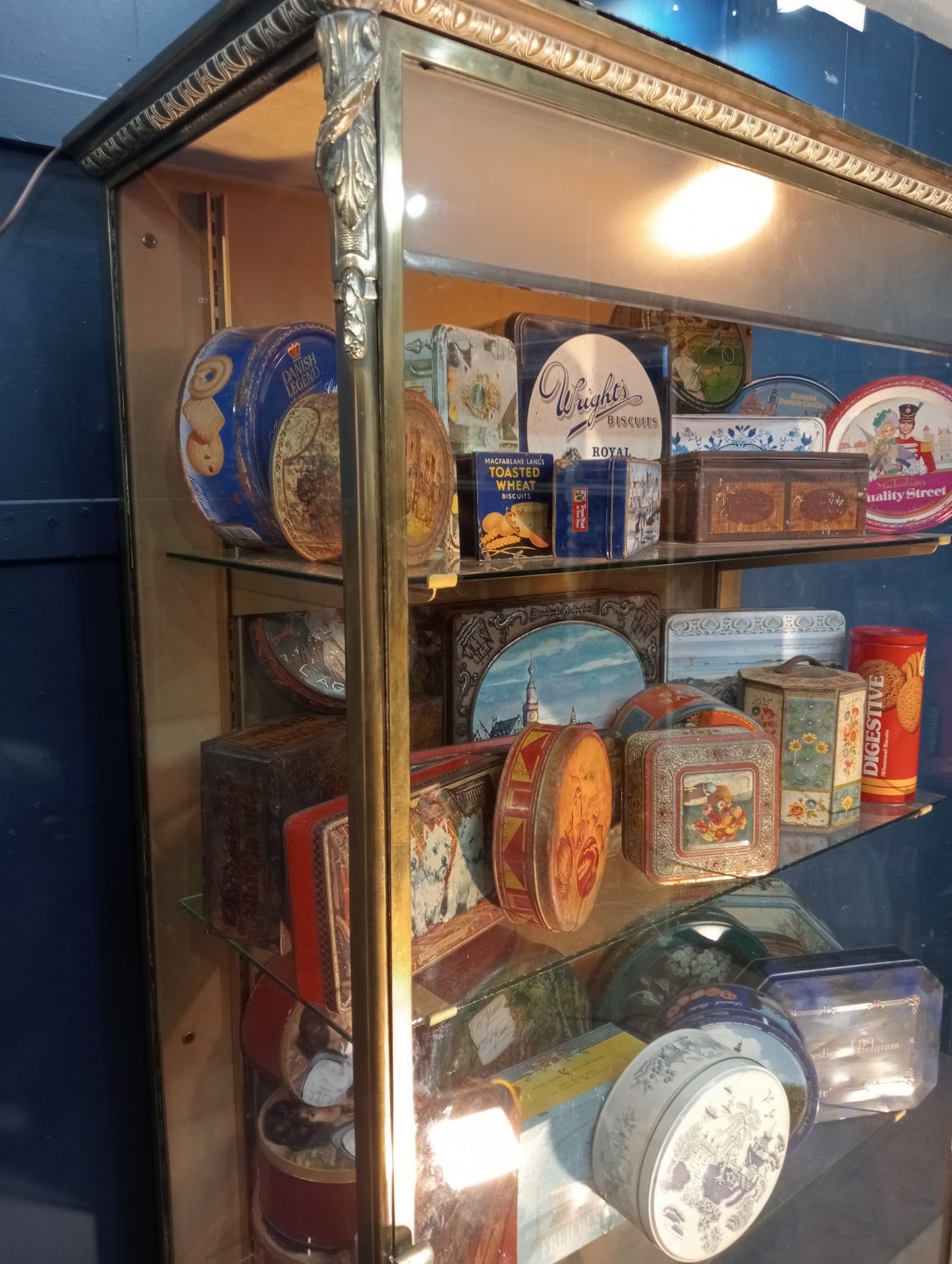 Brass glazed shop cabinet display with single drawer on brass feet with lights