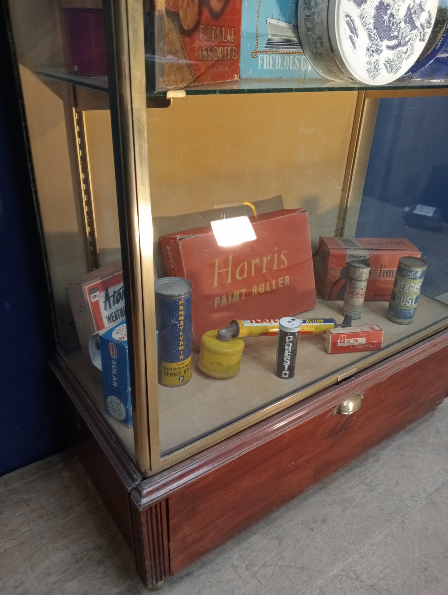 Brass glazed shop cabinet display with single drawer on brass feet with lights