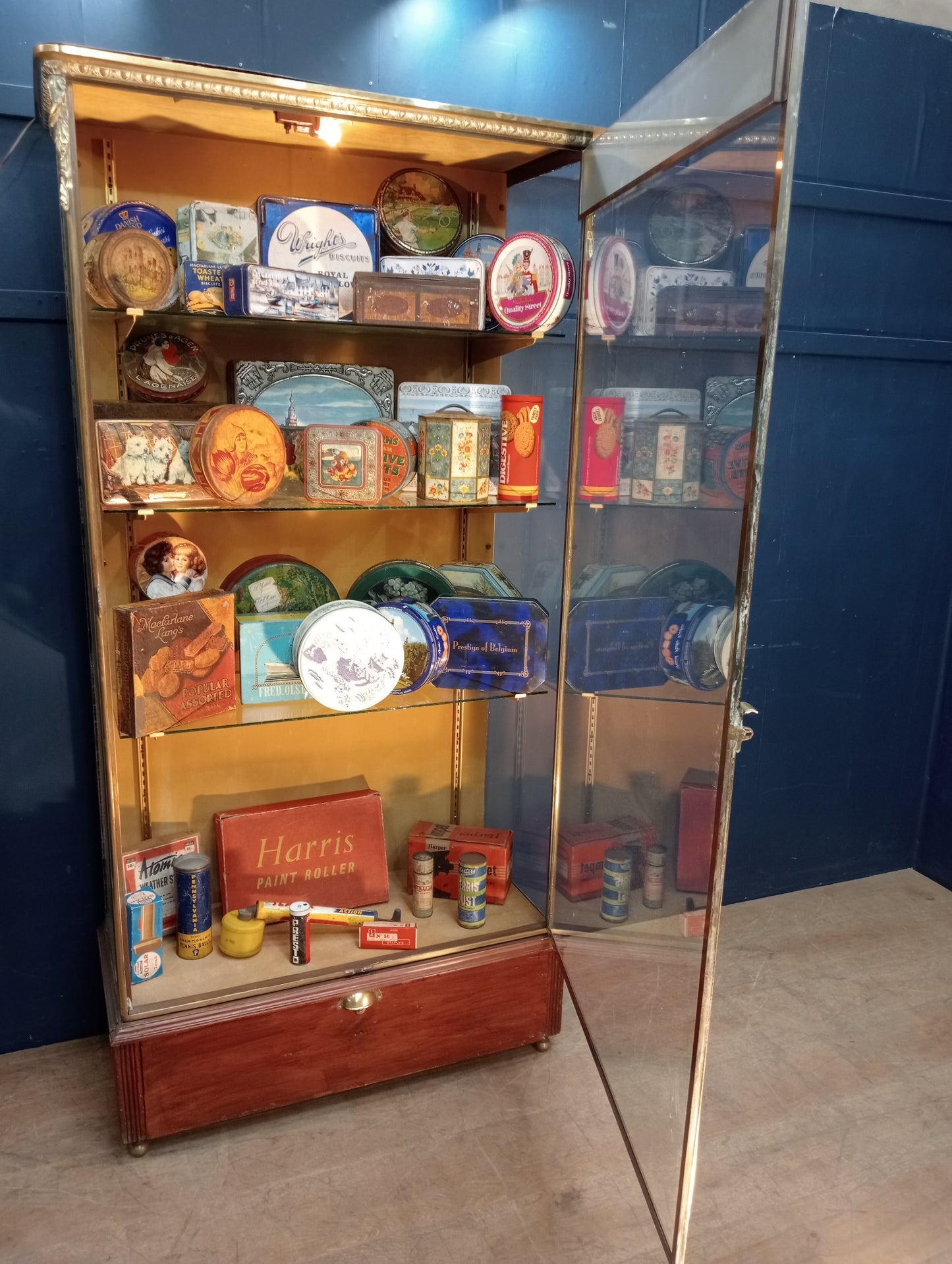 Brass glazed shop cabinet display with single drawer on brass feet with lights