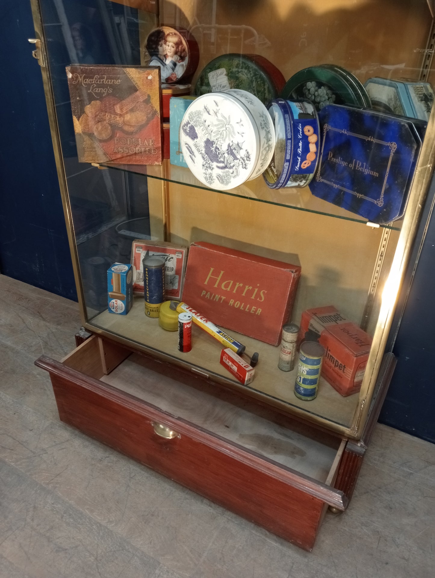 Brass glazed shop cabinet display with single drawer on brass feet with lights