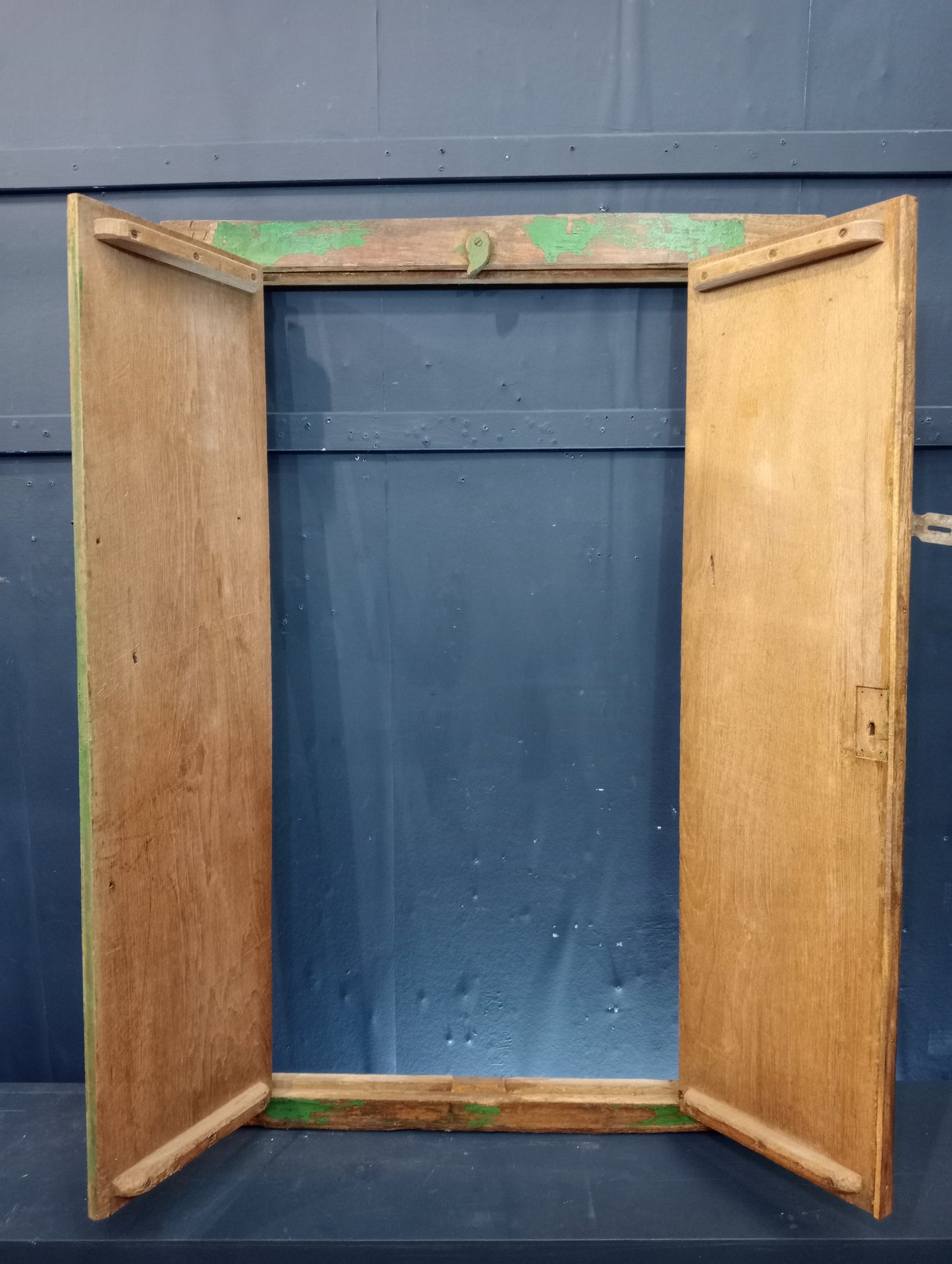 Green patina window shutter with floral design