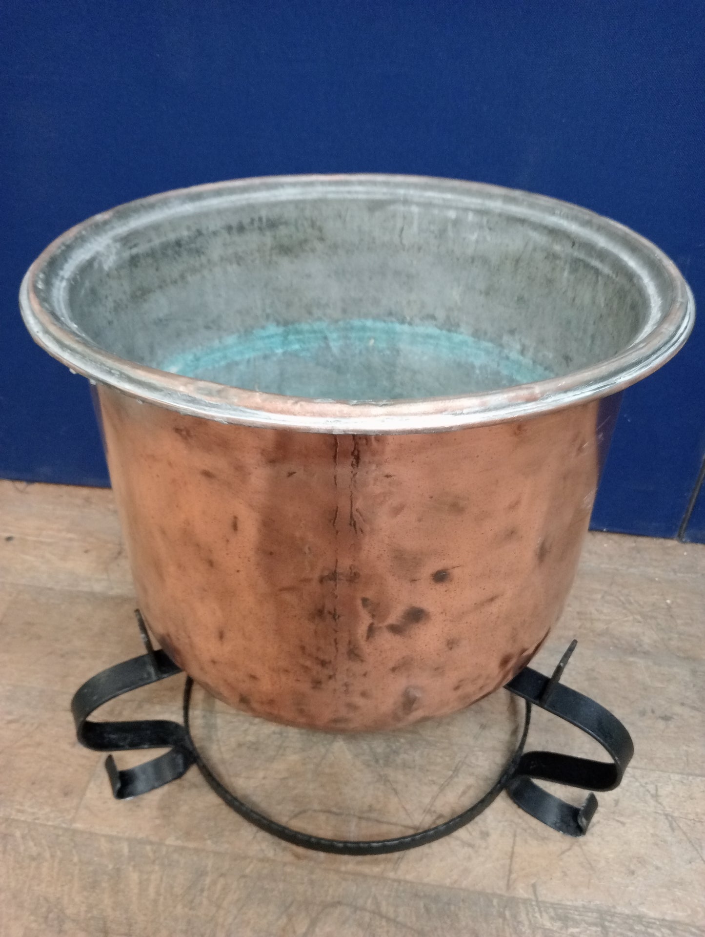 Large copper pot on wrought iron base scroll legs