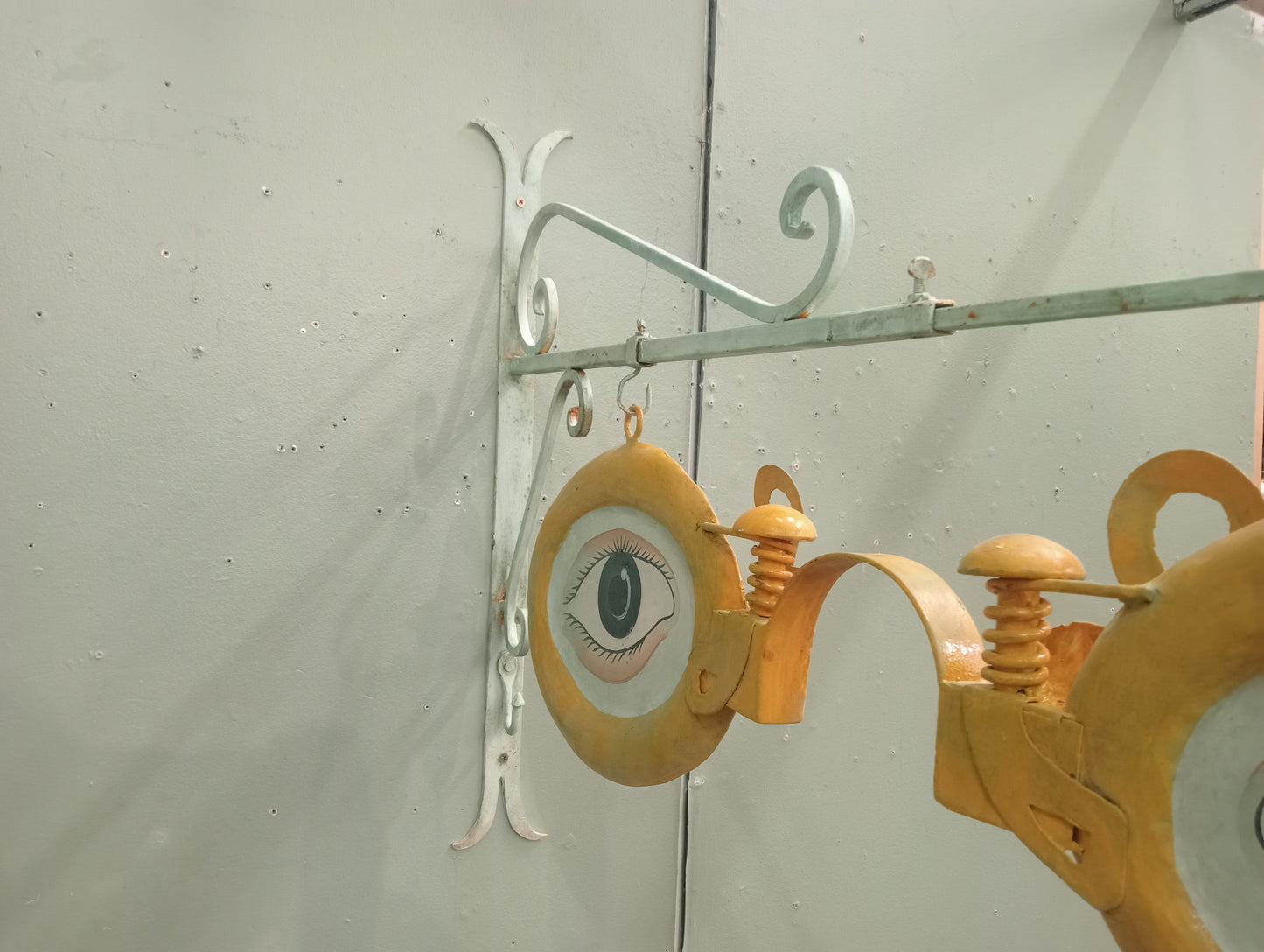 Metal opticians advertising sign on metal bracket