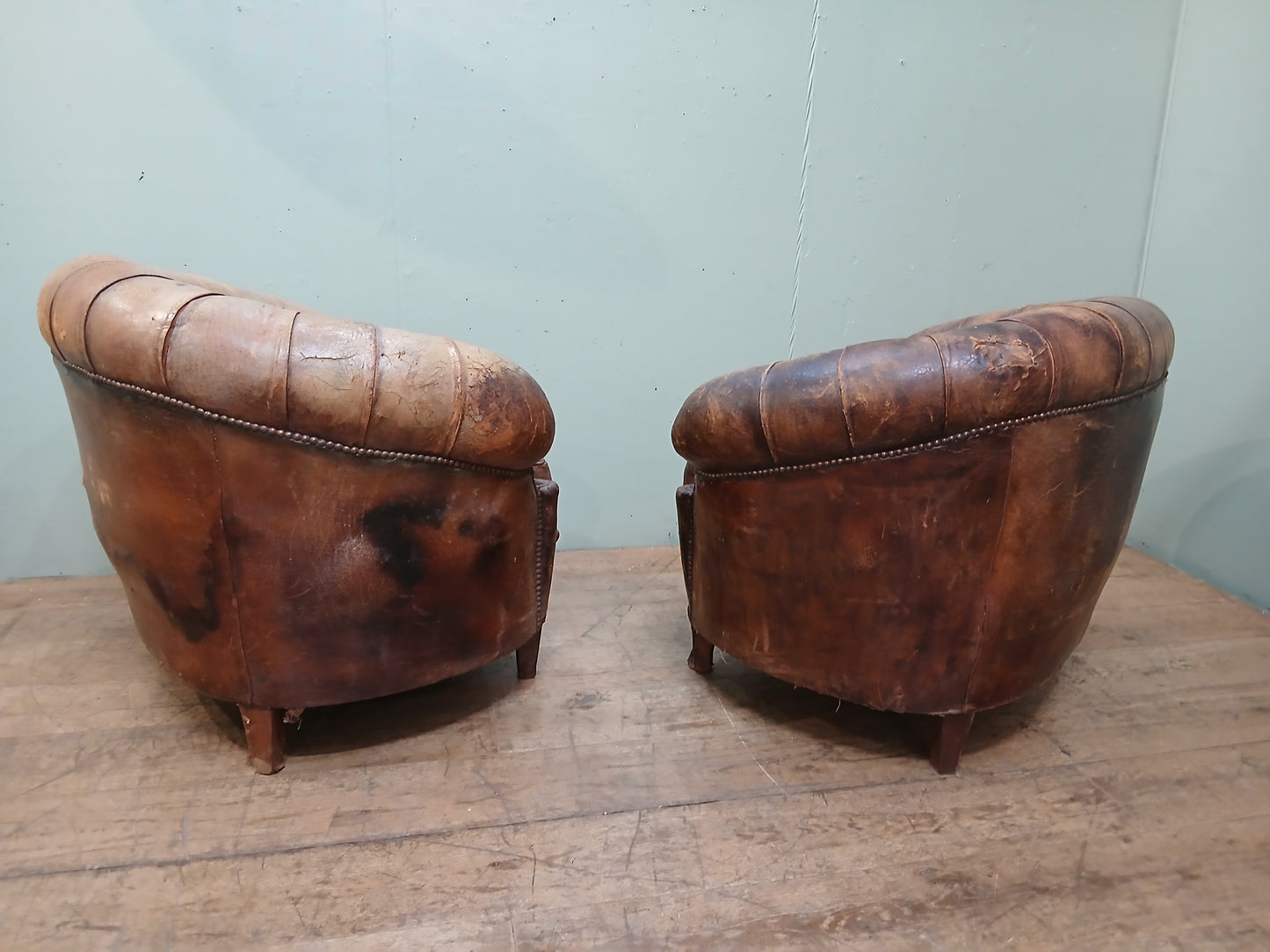 Pair of Italian distressed club chairs deep button
