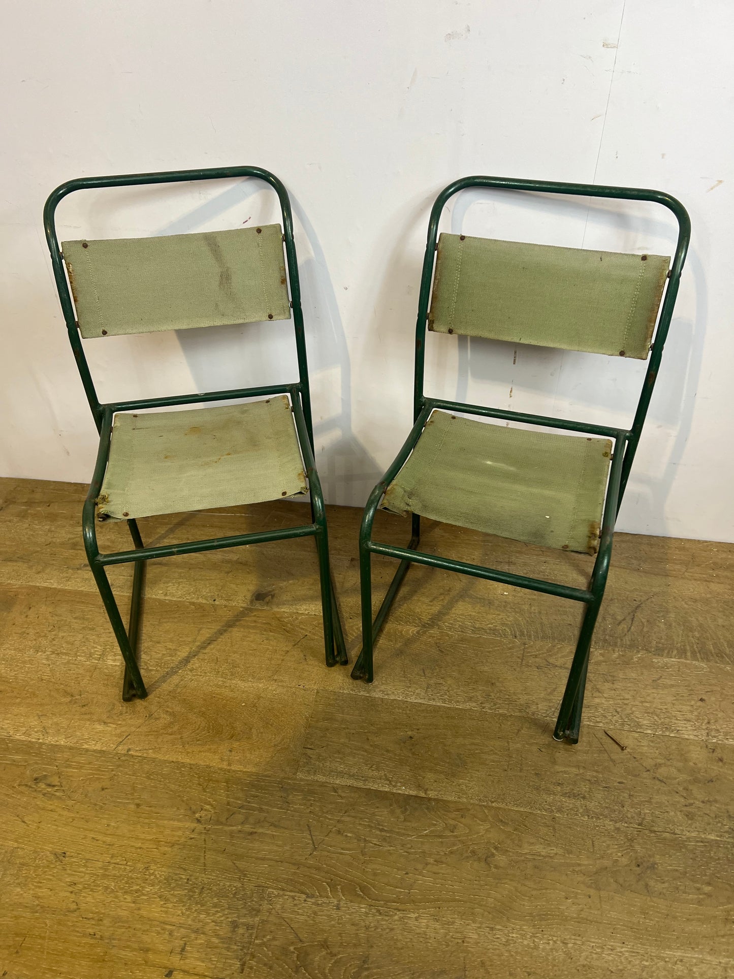 Pair of green metal stacking chairs
