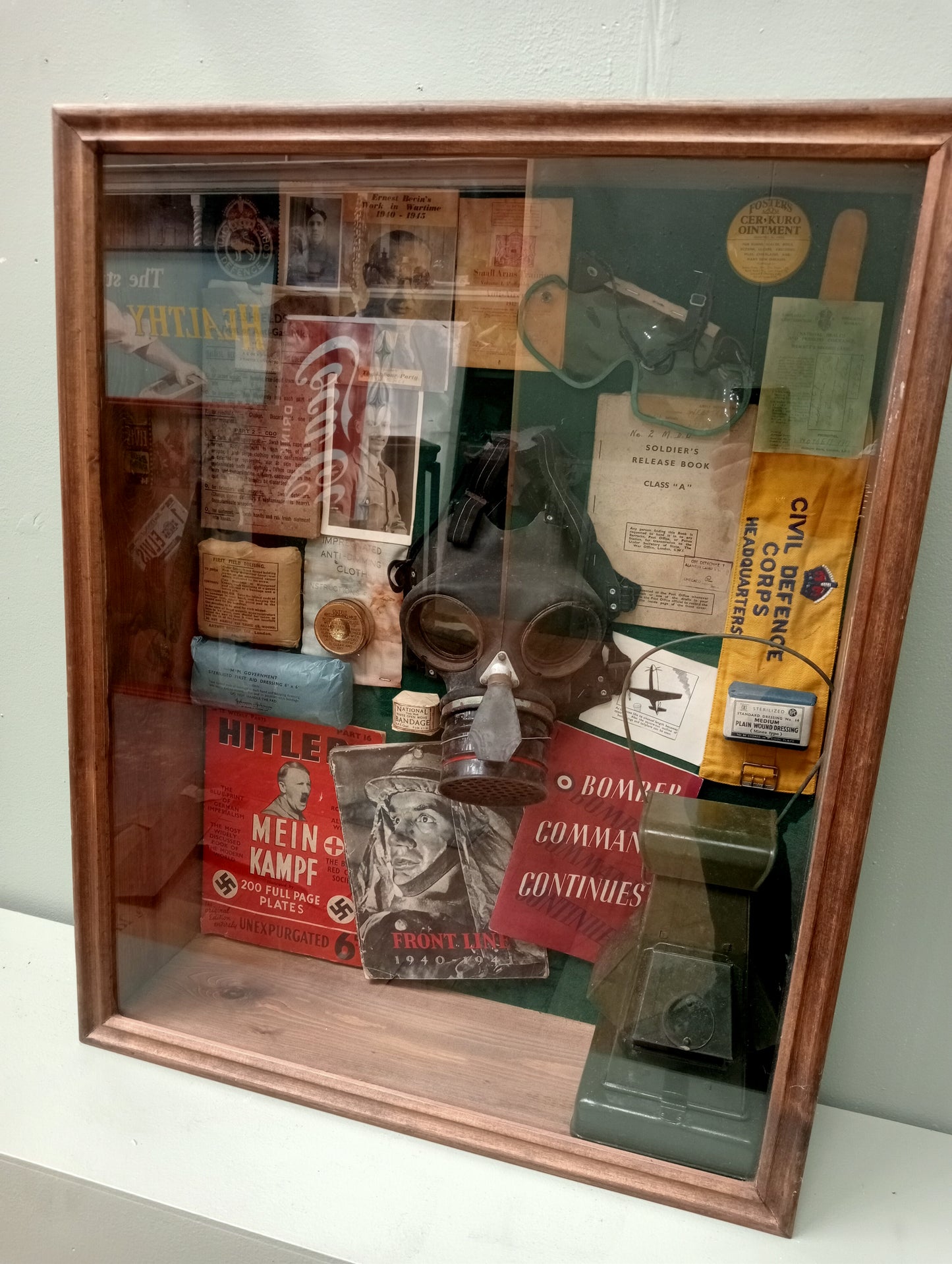 Wartime glazed showcase , gasmask light , field dressisngs. Books , old photos
