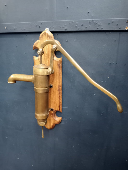 Brass pump on oak plaque