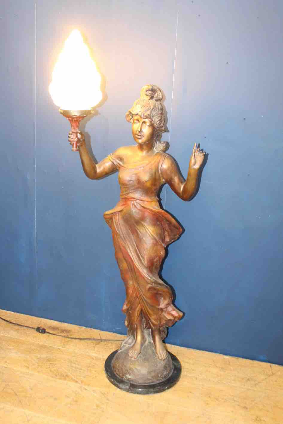 Bronze lady holding light with flame shade