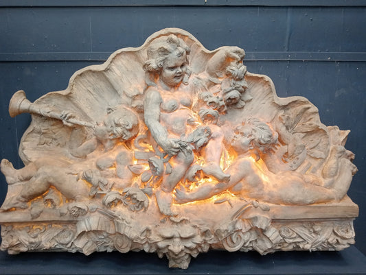 Fiberglass ornate wall mounted plaque depicting musical cherubs