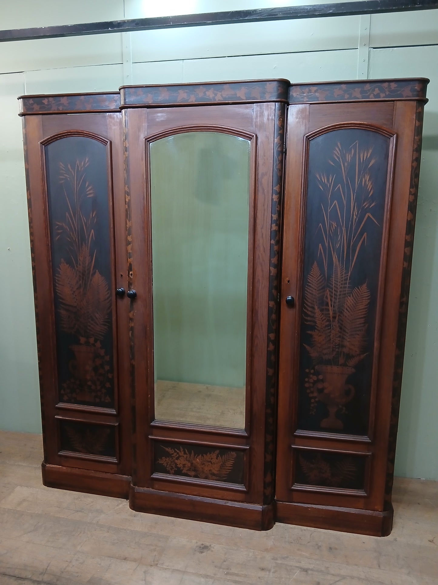 Irish George III style triple fern ware wardrobe with 2 doors to each side internal brass clothes rail central pane; with dome topped mirror, drawer to base