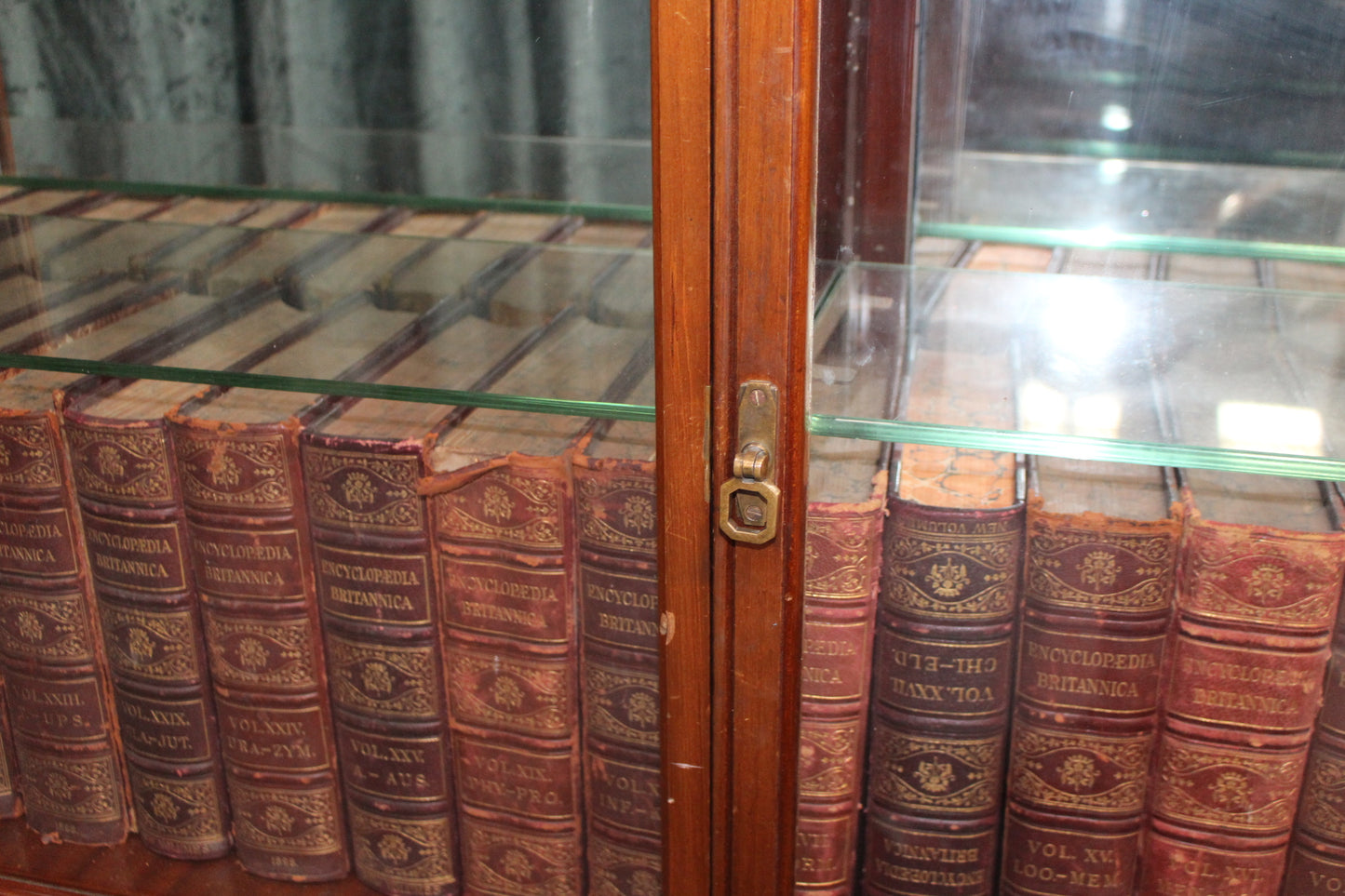 Mahogany shop display cabinet with two glazed doors over four short drawers raised on plinth base