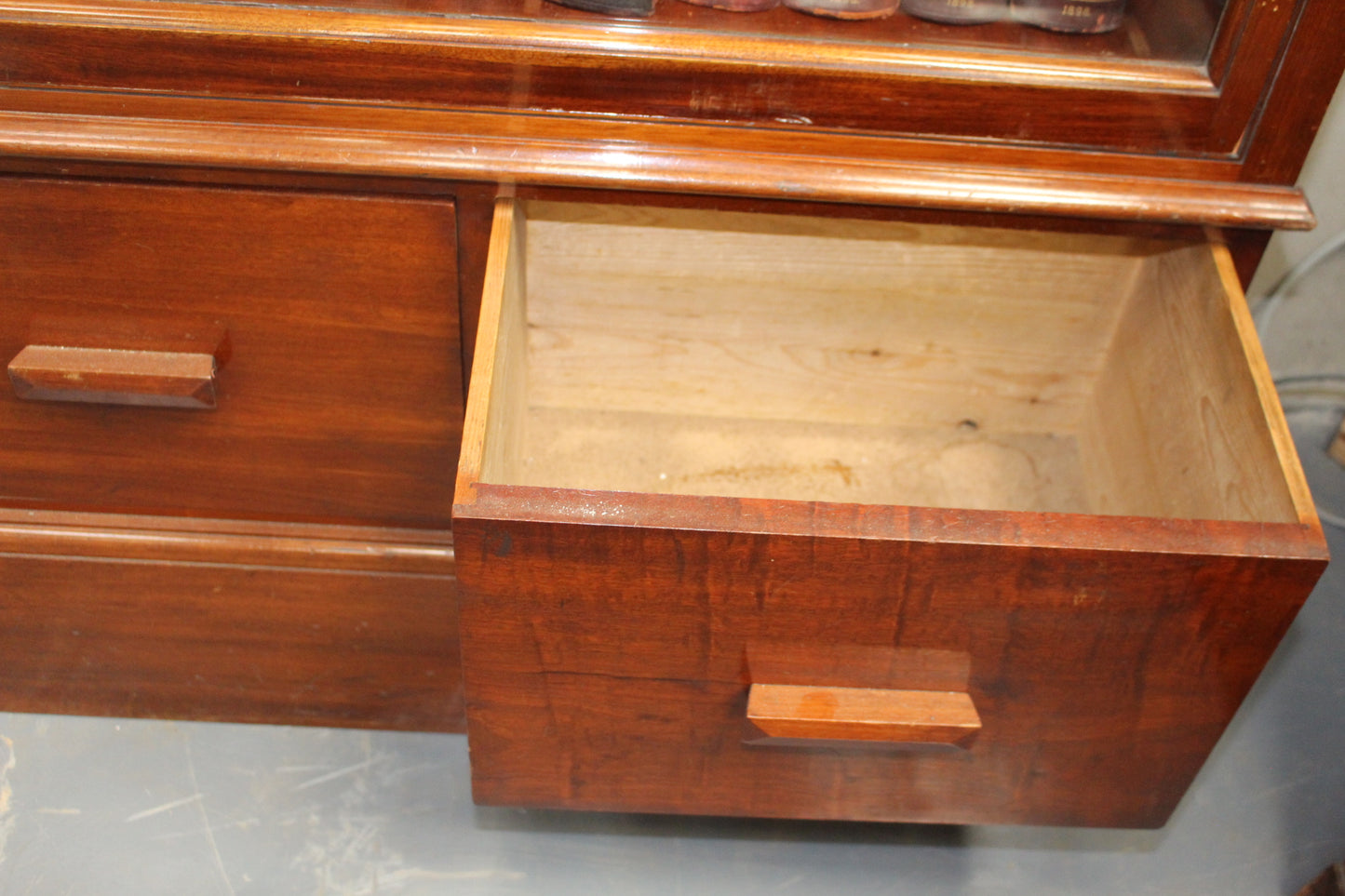 Mahogany shop display cabinet with two glazed doors over four short drawers raised on plinth base