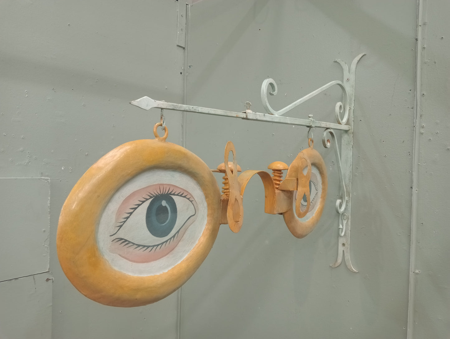 Metal opticians advertising sign on metal bracket