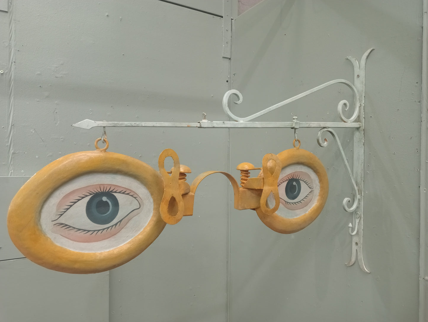 Metal opticians advertising sign on metal bracket