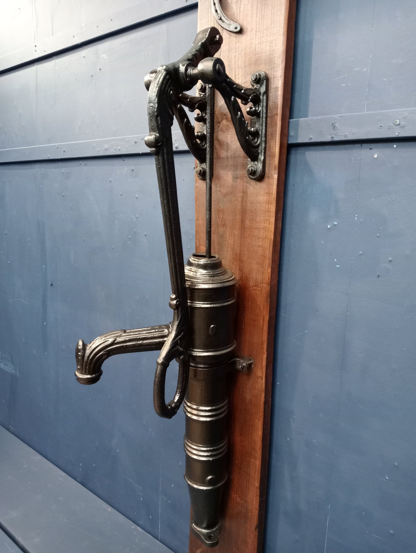 Ornate cast iron pump on wooden board