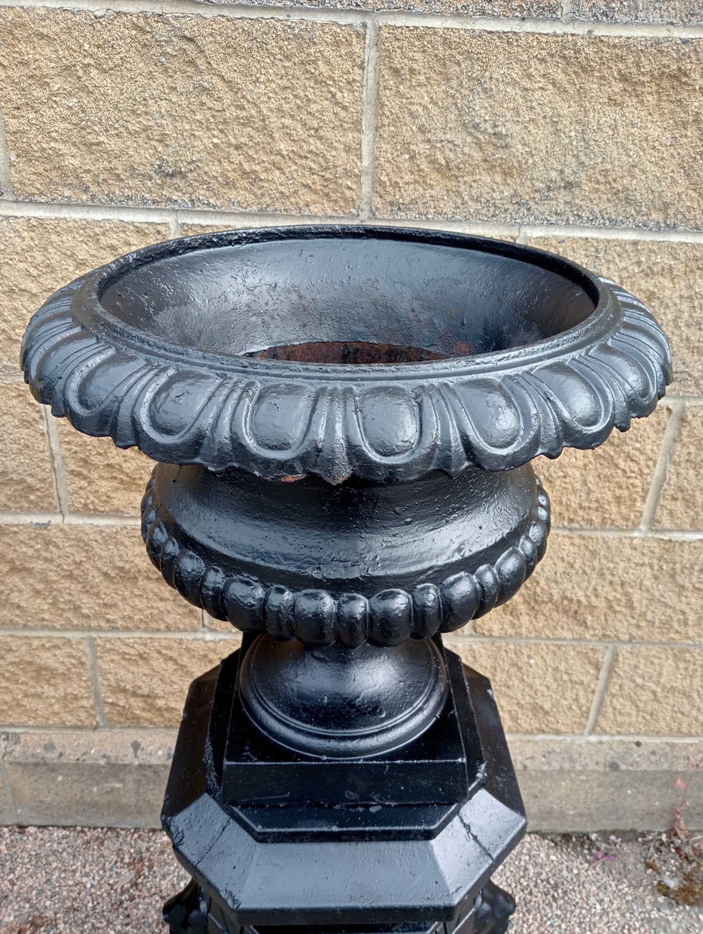 Pair of Cast iron urns on stone base with lions head decoration