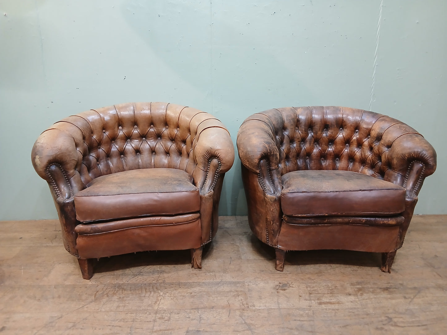 Pair of Italian distressed club chairs deep button