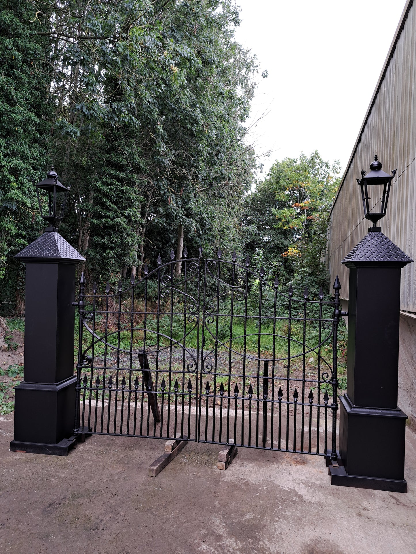 Pair of cast-steel posts with Georgian cast iron scroll gates with pointed finials