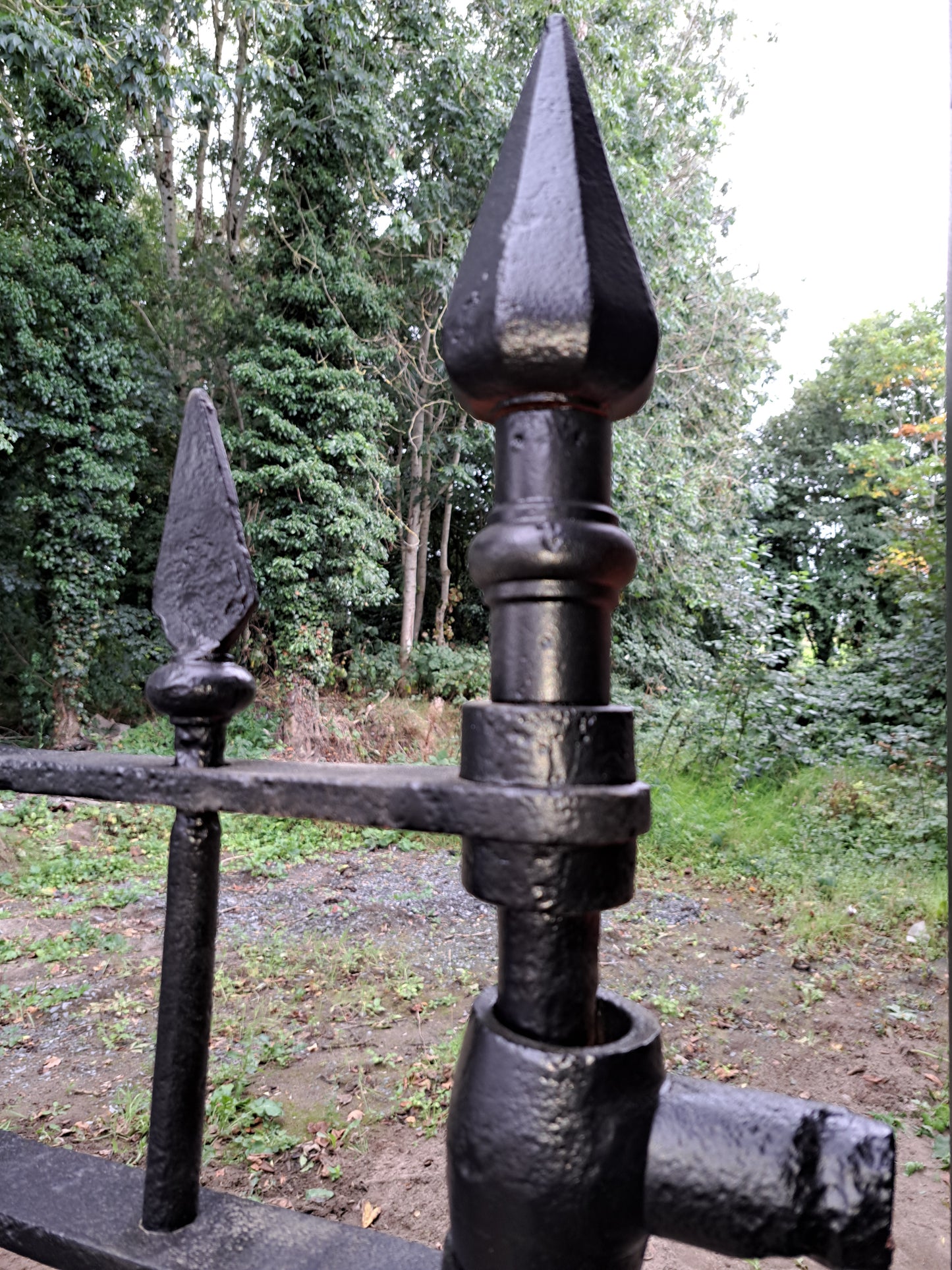 Pair of cast-steel posts with Georgian cast iron scroll gates with pointed finials