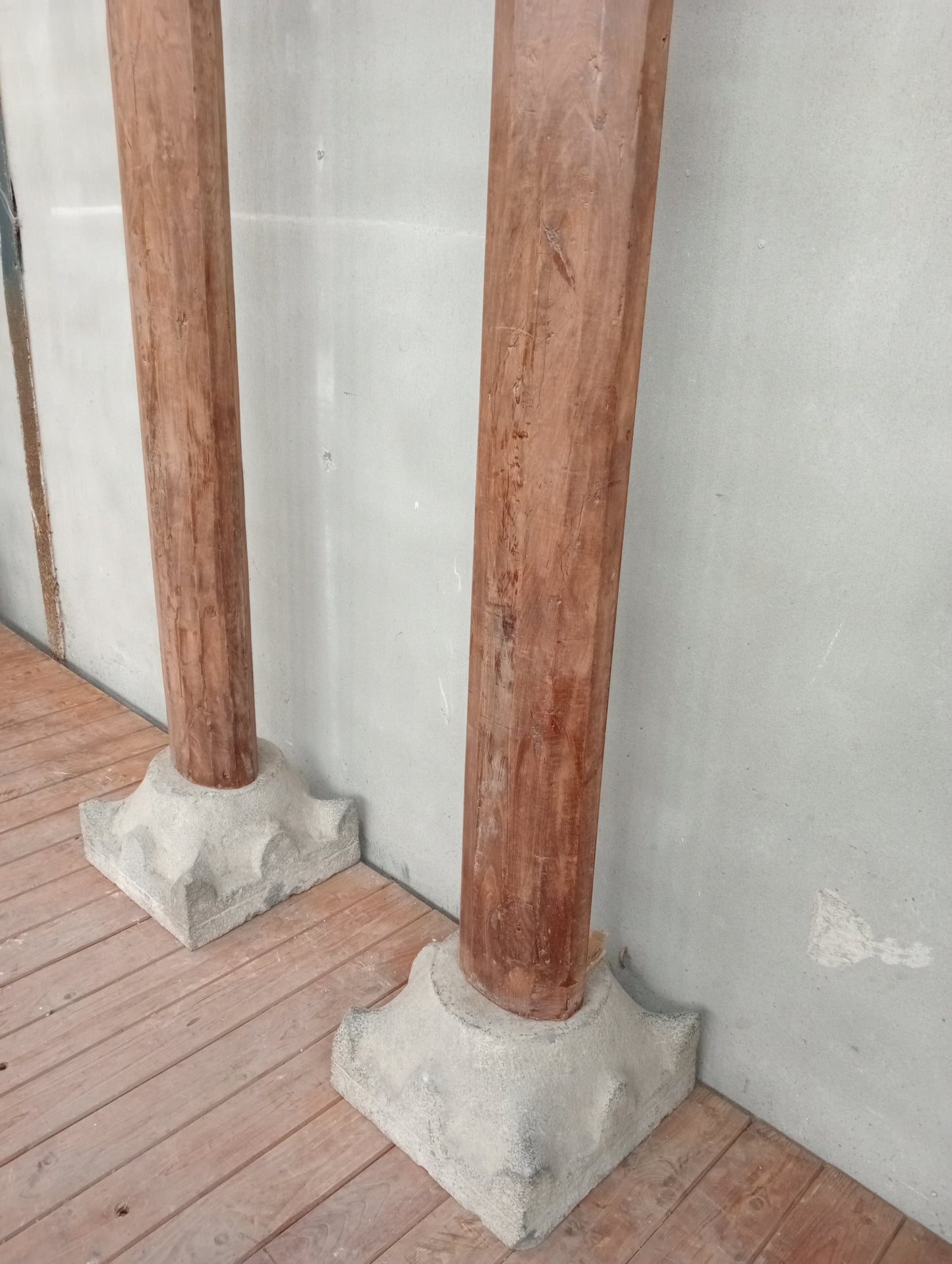 Pair of wooden columns with stone base