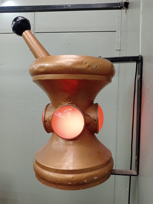 Rare early 20th C pharmacy trade sign in the form of a mortar and pestle. Gilded colour with red lenses on 4 sides. In working order