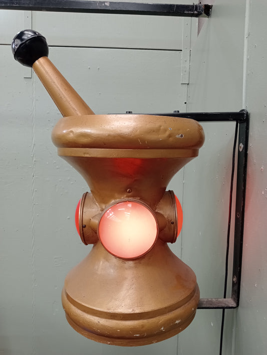 Rare early 20th C Pharmacy Trade Sign in the form of a mortar and pestle .In working order. Gilded colour with red lenses on 4 sides.