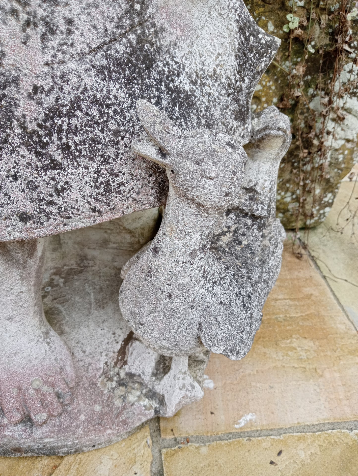 Stone girl figure with ducks